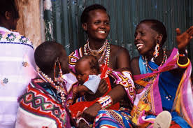 Women and a child smiling together during a community gathering.
