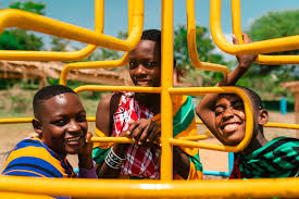Young people sharing a joyful moment on playground equipment outdoors.